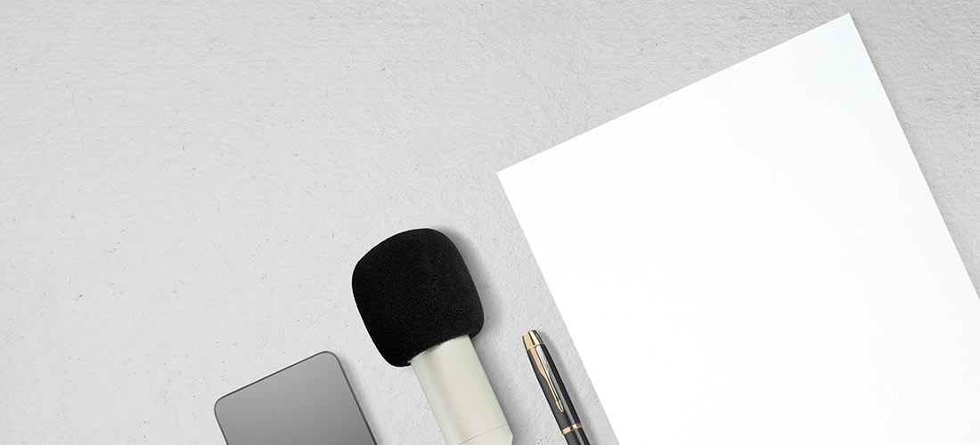 Micrófono, folio en blanco, libreta y teléfono móvil